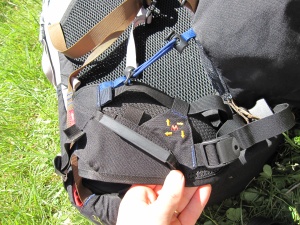 Vue latérale de la ceinture ventrale, avec un porte-matériel et, en bleu, un des points de connexion de la poche avant