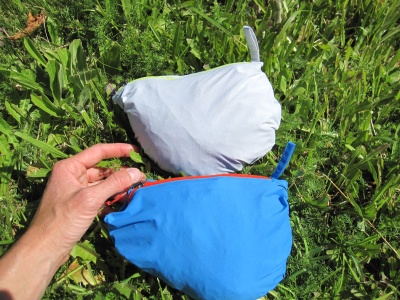 Les Helium Rain rangées dans leur housse (homme en bleu, femme en blanc), on voit l'anneau de tissu qui permet une attache facile au baudrier, au sac à dos, etc. 