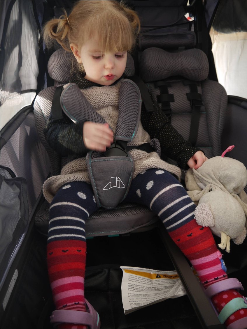 Remorque vélo enfant 2 places Nordic Cab Urban - enfant de 2 ans sur un siège, bien attachée et confortablement installée