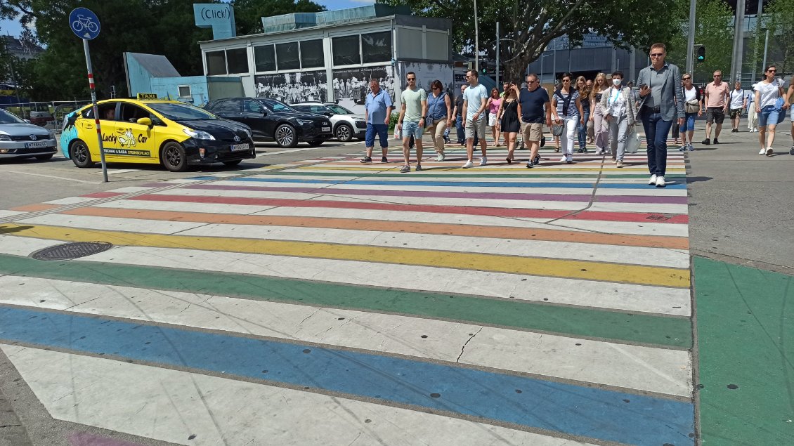 J22. Je me trouve à Vienne pendant la Rainbow Parade. La ville n'hésite pas à défendre la cause de la diversité et plus spécifiquement celle de l'homosexualité avec ce passage piéton permanent aux couleurs de l'arc-en-ciel.